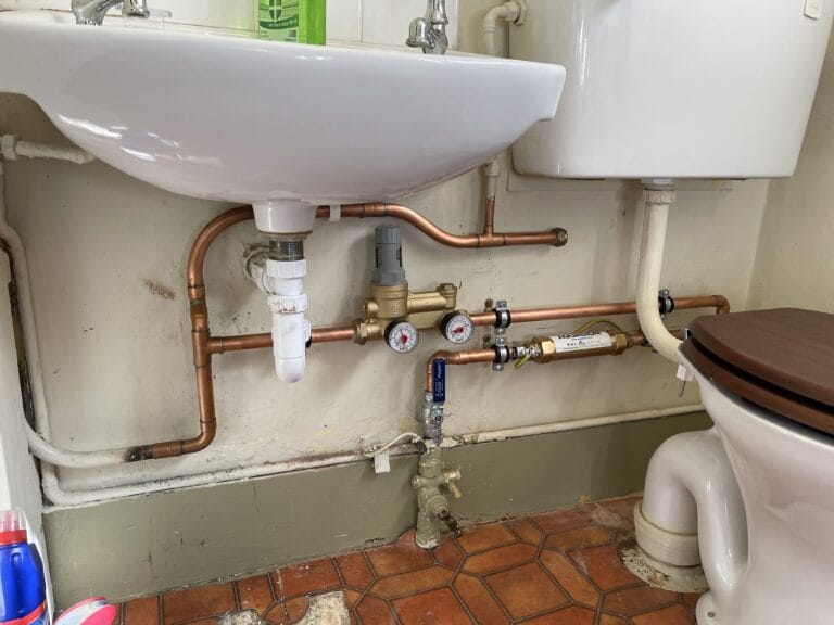 Plumber repairing pipework during a plumbing problem in a Brundall home