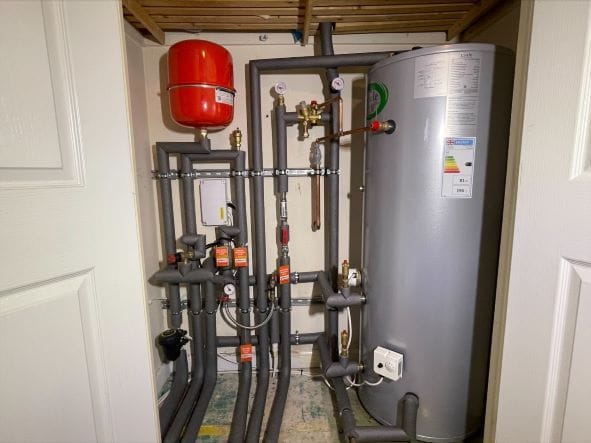 Plumber checking an unvented hot water cylinder in a Poringland home