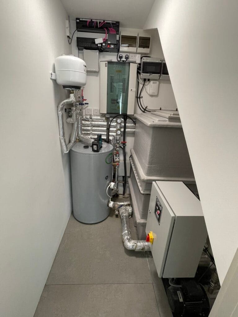 Commercial water pressure boosting system with hot water cylinder, expansion vessel and plant room pipework in Norfolk