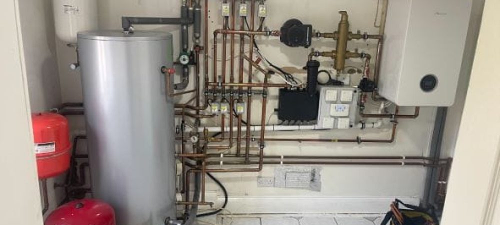 Heating engineer checking radiators and smart controls in a Poringland family home