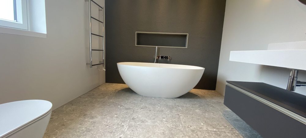 Plumber assessing shower pressure and bathroom layout in a Hunstanton bungalow