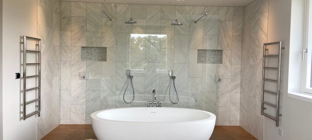 Plumber assessing bathroom layout and hot water requirements in a Wymondham home