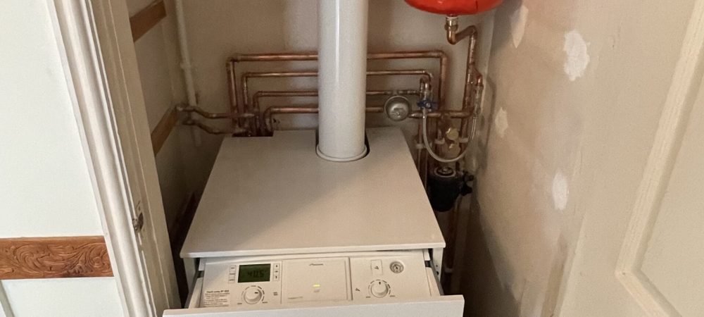 Heating engineer assessing an oil boiler replacement in an off-grid Norfolk home
