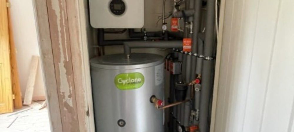 Heating engineer checking a hot water cylinder in a Downham Market home