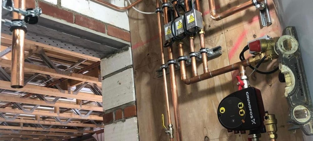 Heating engineer checking smart thermostat and heating controls in a Downham Market home