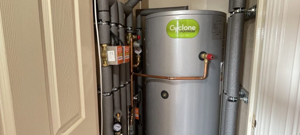 Engineer checking a hot water cylinder in a Costessey home