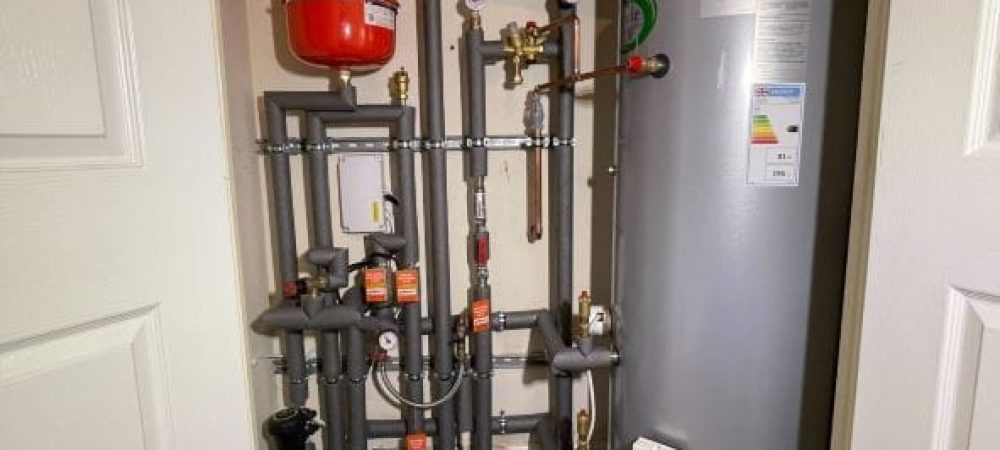 Plumber checking an unvented hot water cylinder in a Poringland home