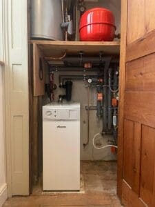 Indoor oil boiler installation with hot water cylinder and expansion vessel in a utility cupboard