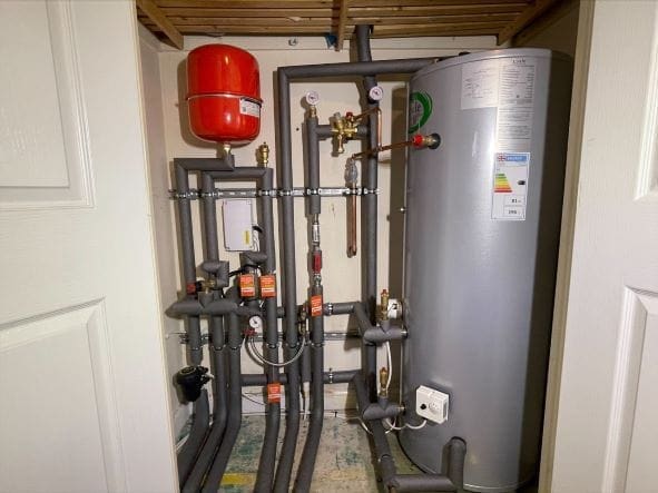Choosing the Right Hot Water Setup for Holt Homes with Annexes, Guest Rooms or Multiple Bathrooms | Allstar Systems Ltd Plumber checking hot water setup for a Holt home with guest rooms and annexes